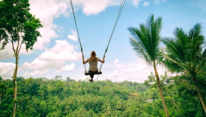 a woman on an open swing in indonesia, crazy bucket list idea