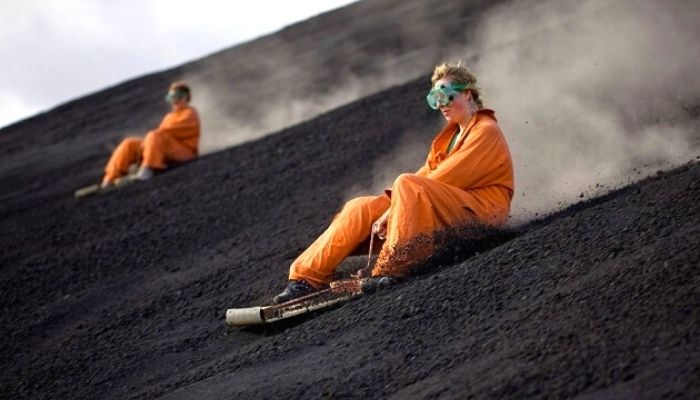 two people volcano boarding or surfing in Nicaragua