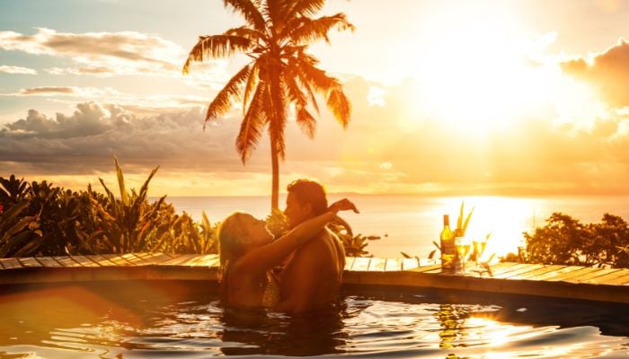 a couple in love overlooking a sunset in a pool